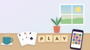 A sunny table with a cup of coffee, a fan of playing cards, wooden letter tiles spelling PLAY and a phone showing a colorful tile puzzle, with a window and a plant behind.
